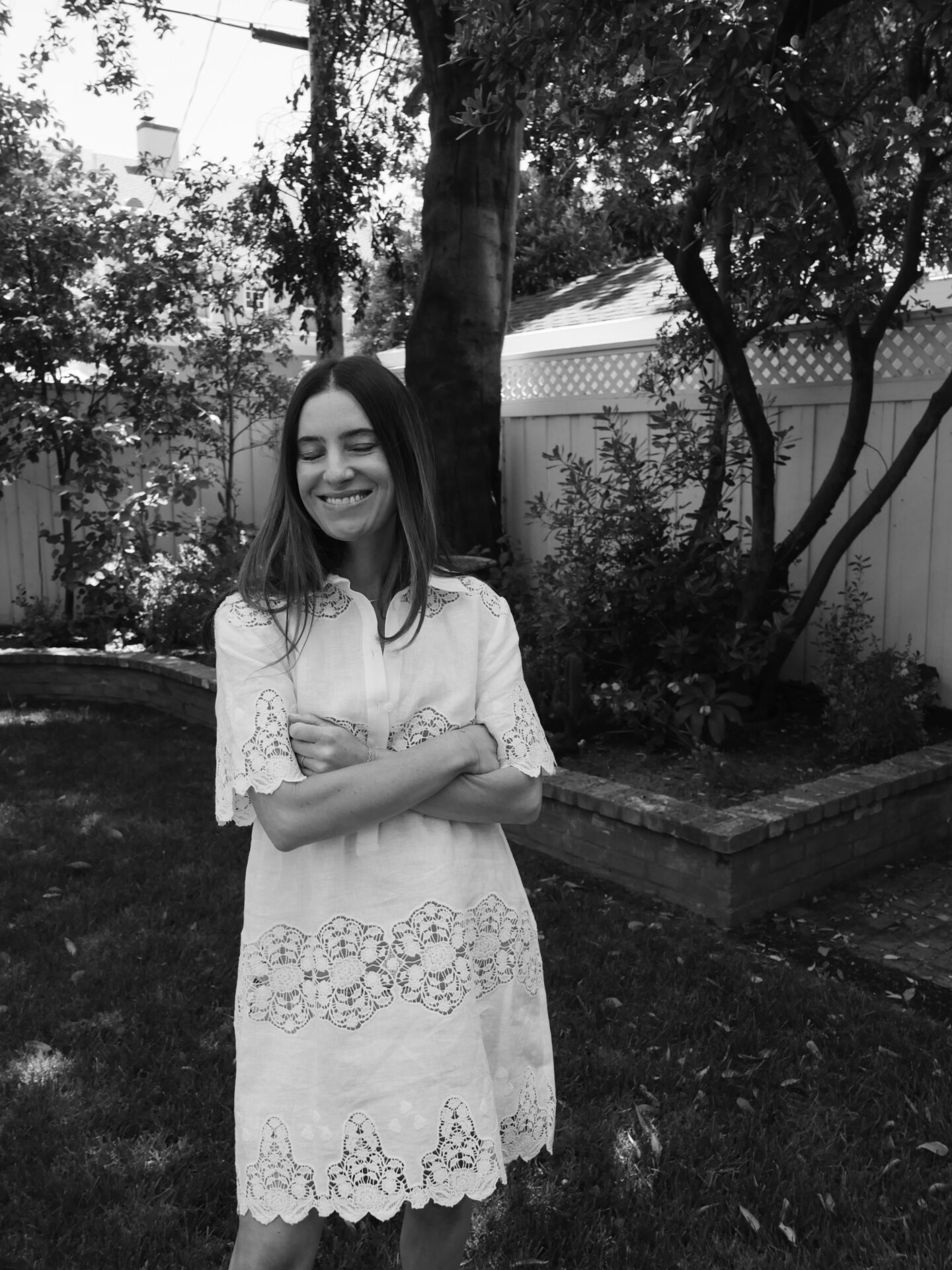 woman in a backyard and wearing white lace dress