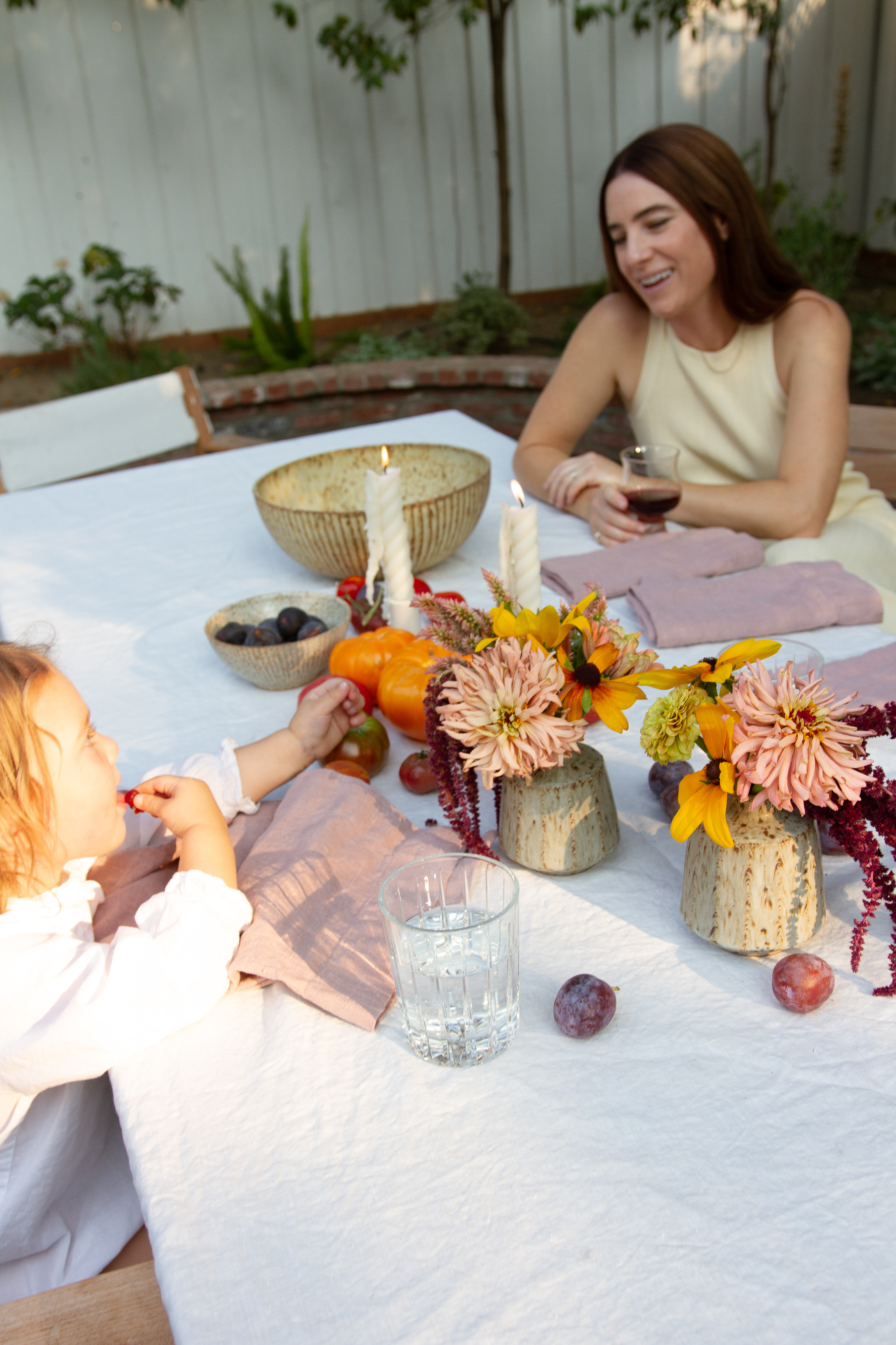 Talking with Willow at a candlelit dinner table set with Wrel Living linens and Zoe Dering bud vases.