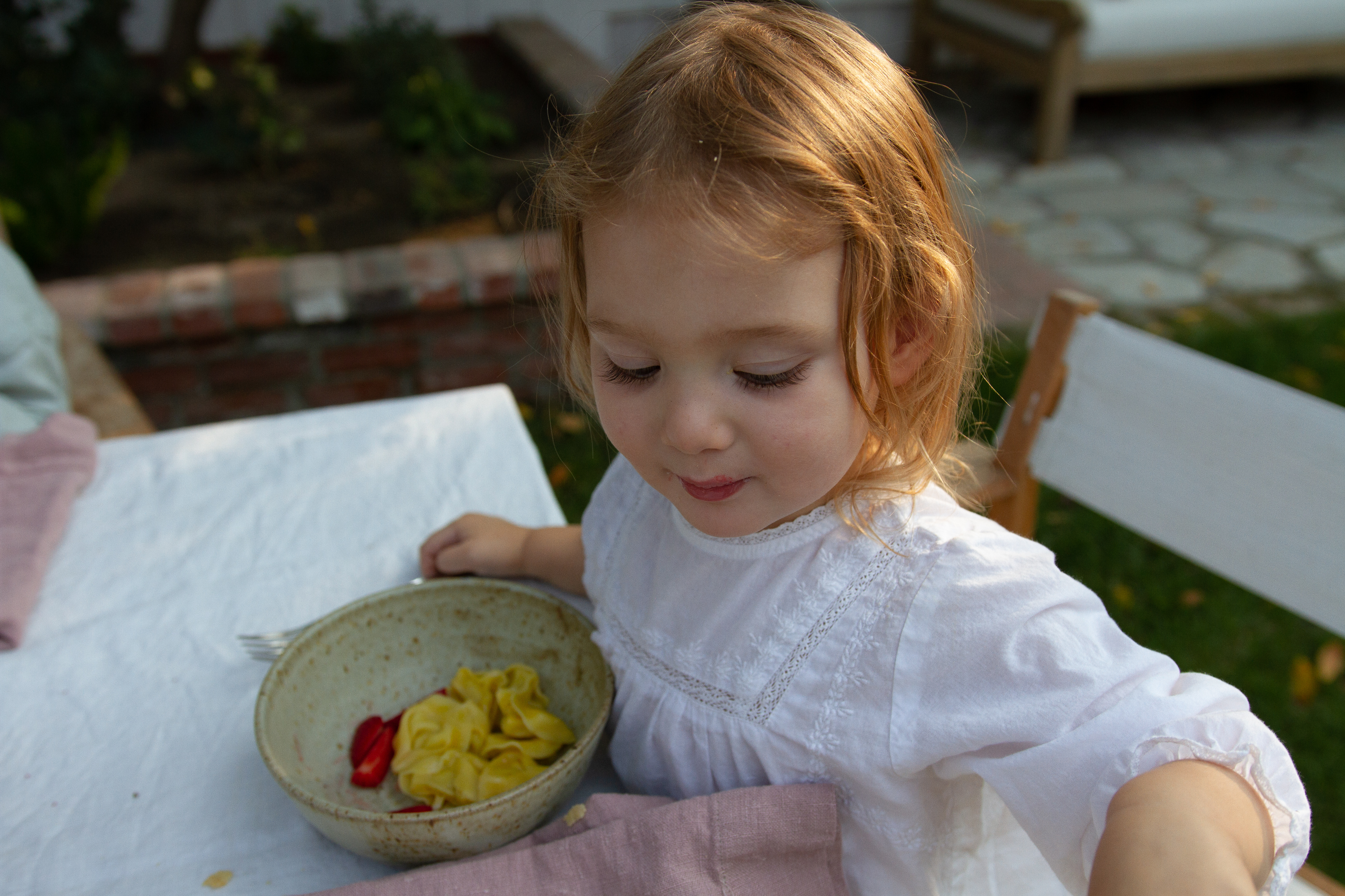 Willow eating dinner with our blush Wrel Living linen napkins.