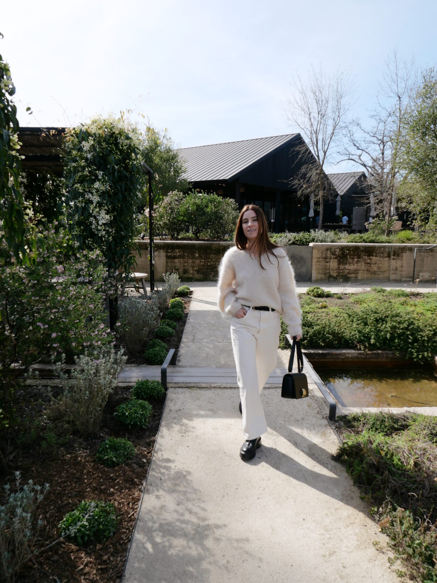 Alicia Lund walking through the garden at Flowers Winery in Healdsburg dressed in all-white. 
