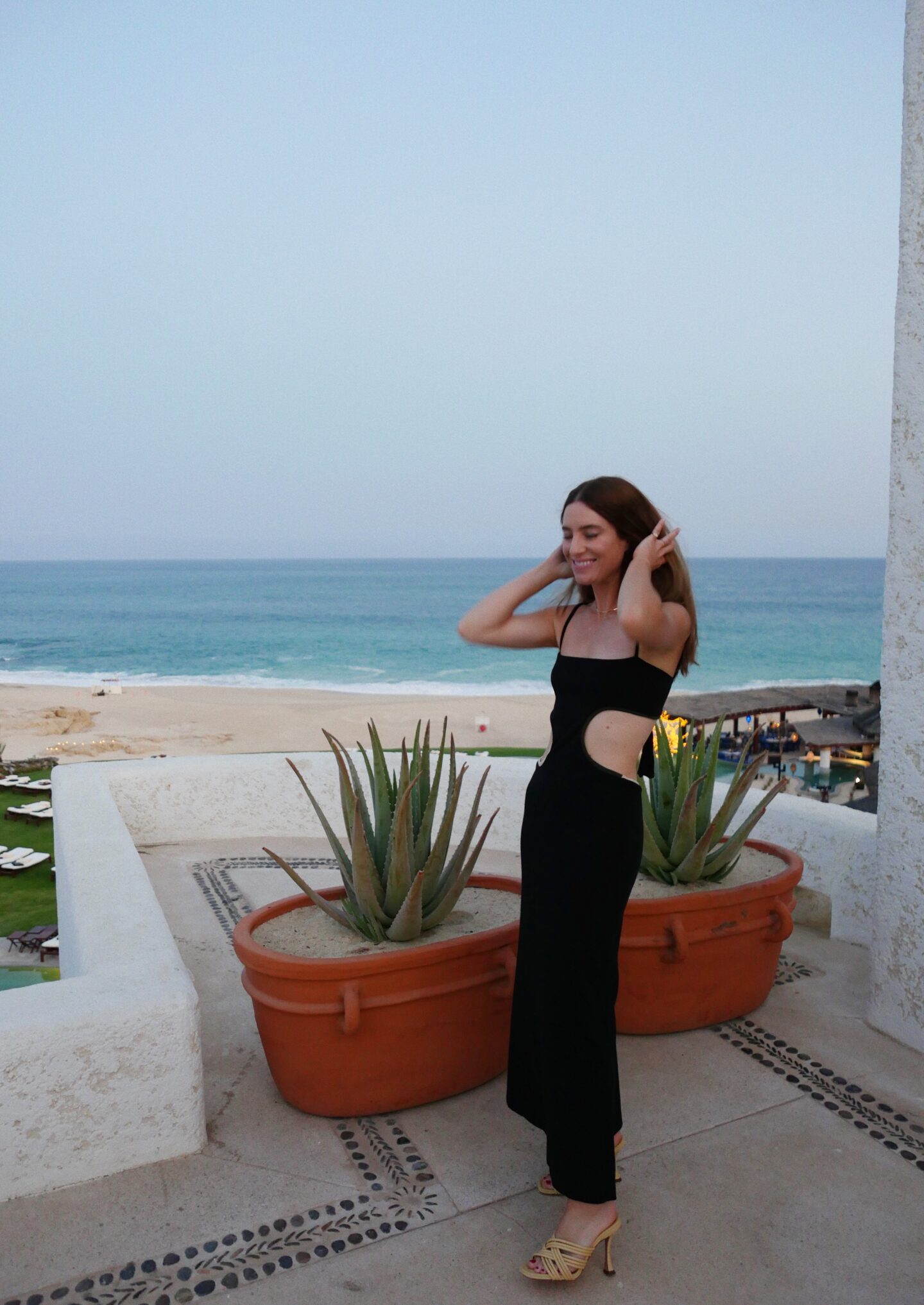 Alicia Lund wearing black cutout dress for Vacation Edit with Saks